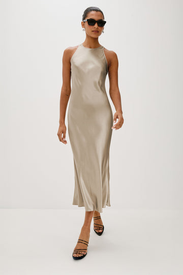 Solene Sleeveless Midi Dress with a Crew Neck and a Tie Keyhole at the Back in Mink Colorway - Front Full Body View Featured on Model wearing sunglasses