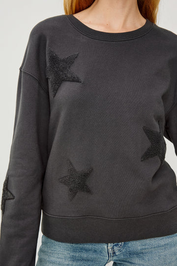 Sonia Long-Sleeve Sweatshirt with a Crew Neck and Charcoal Patch Stars in Washed Black Colorway - Close UP View Featured on Model