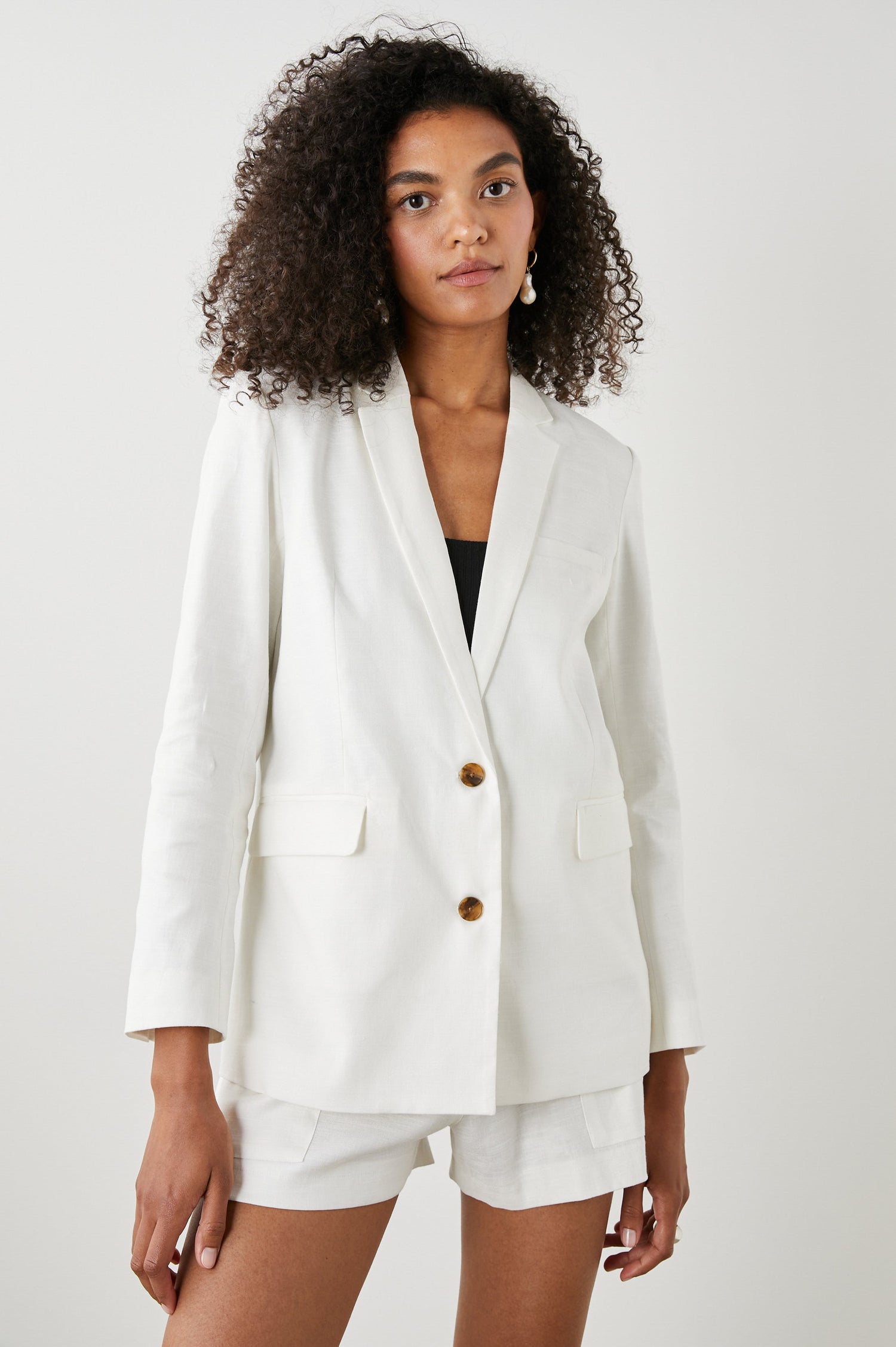 Stanton Blazer with Two Button Closure, Two Front Flap Pockets, a Chest Patch Pocket and Four-Button Cuffs in Creme Colorway - Front View Featured on Model