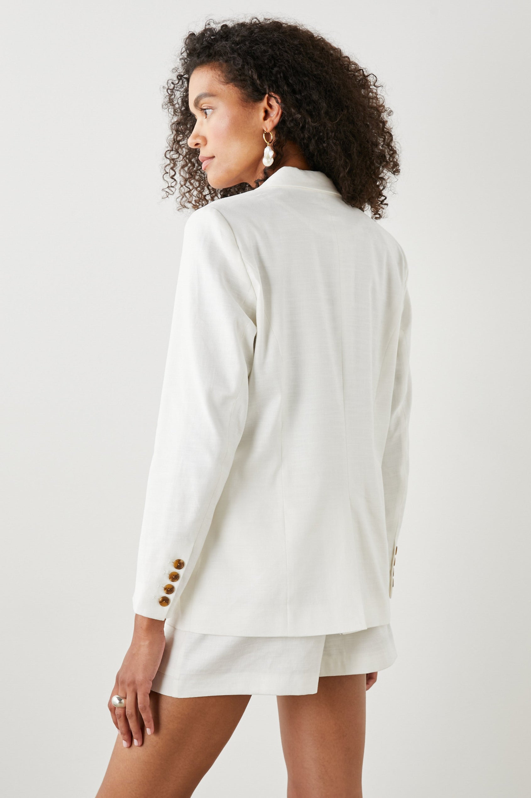 Stanton Blazer with Two Button Closure, Two Front Flap Pockets, a Chest Patch Pocket and Four-Button Cuffs in Creme Colorway - Back View Featured on Model