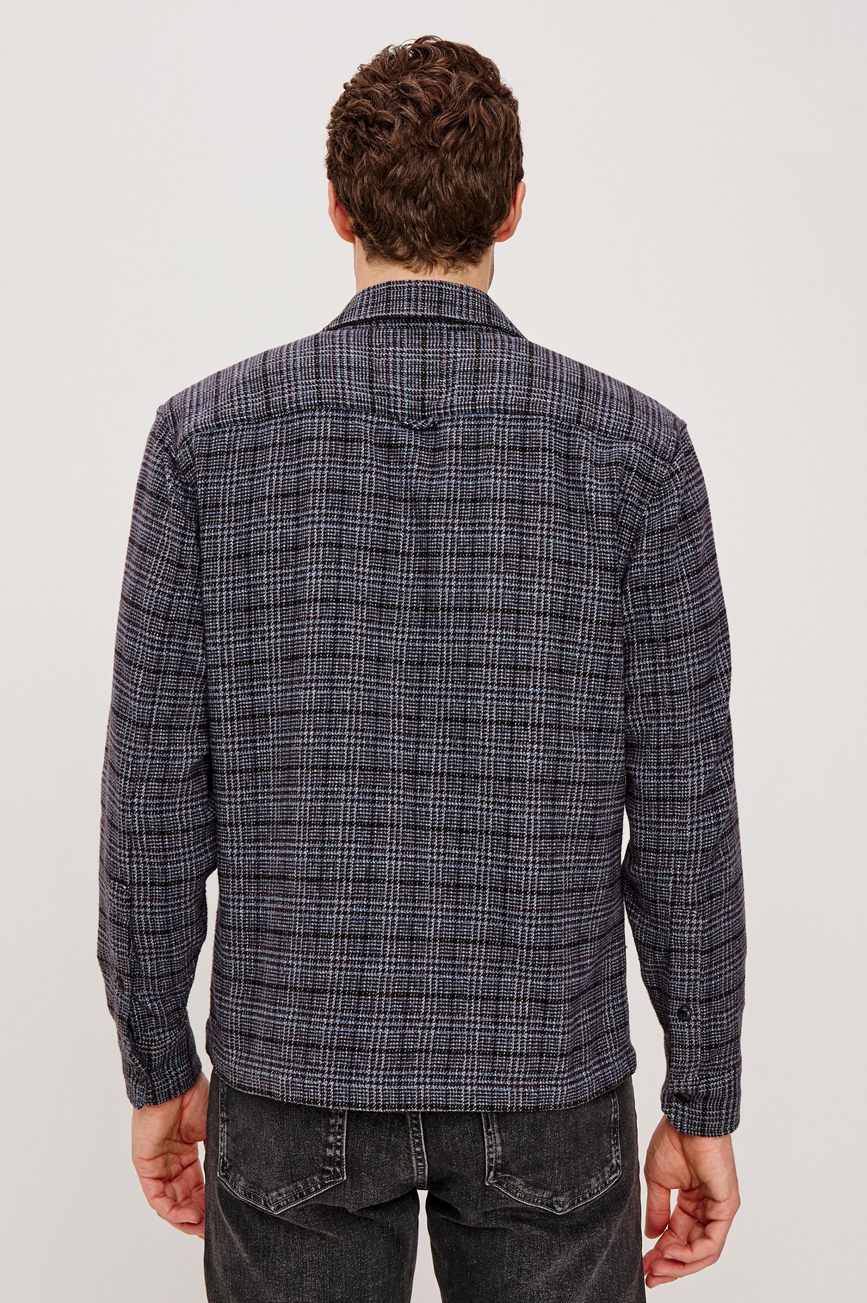 Stellan is a shirt jacket made from heavy brushed cotton with a classic collar, front button closures, chest flap pockets in Cedar Bay, a blue and grey plaid colorway. Back view featured on model.