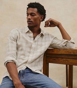 Male model wearing a plaid button down shirt and jeans