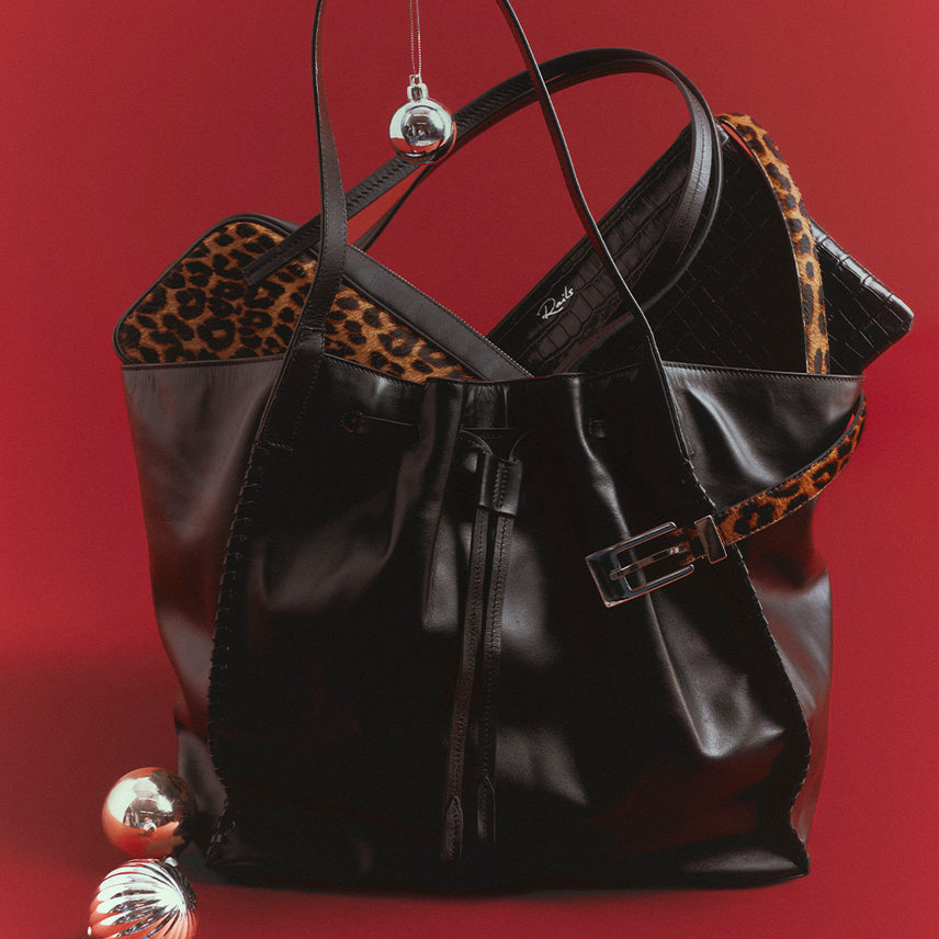 Variety of different color and style handbags placed against a red background.