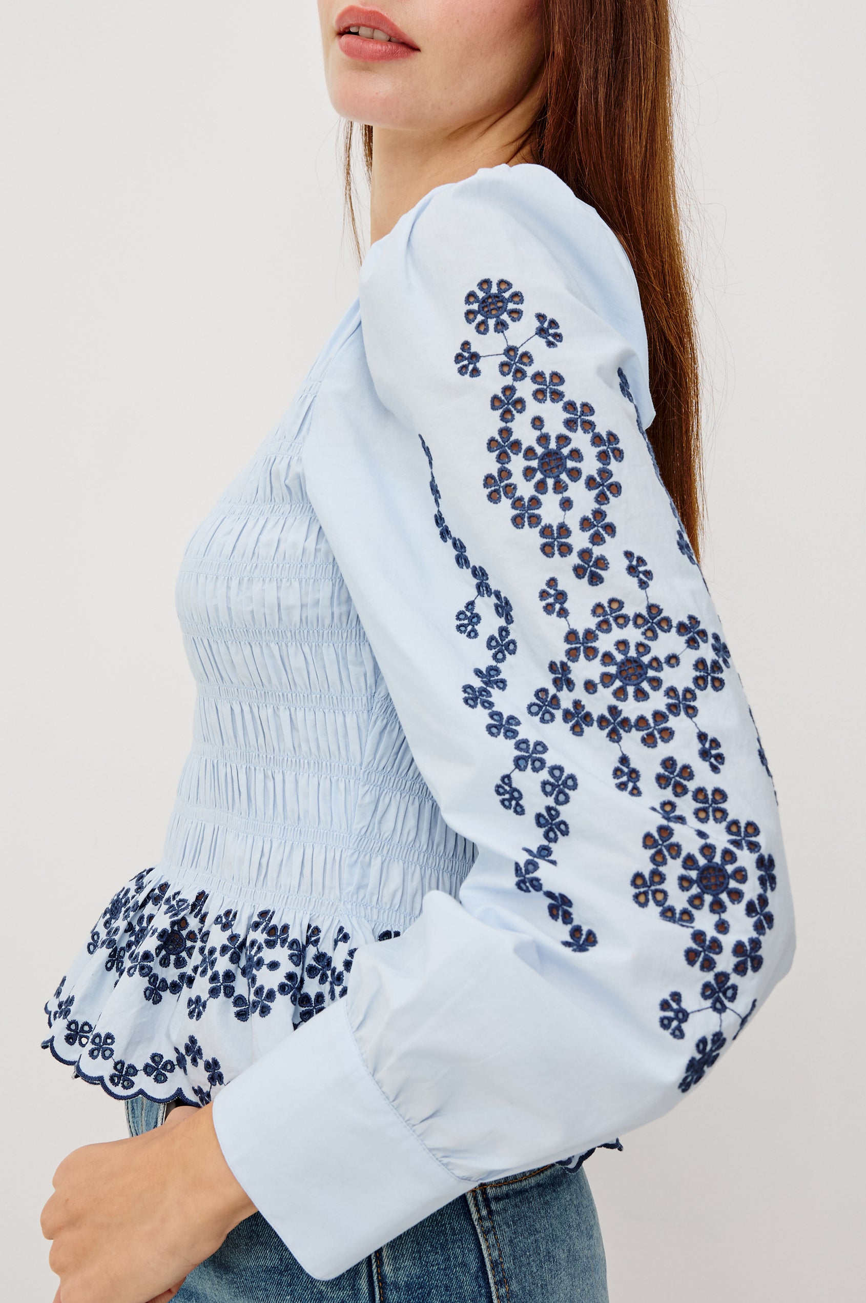 Tabi Blouse Top in Poplin With Smocked Body, Long Puff Sleeves With Fitted Cuffs, Contrast Embroidered Detailing, and Back Keyhole Cutout in Blue Bird Colorway - Upper Body Side Close Up View Featured on Model