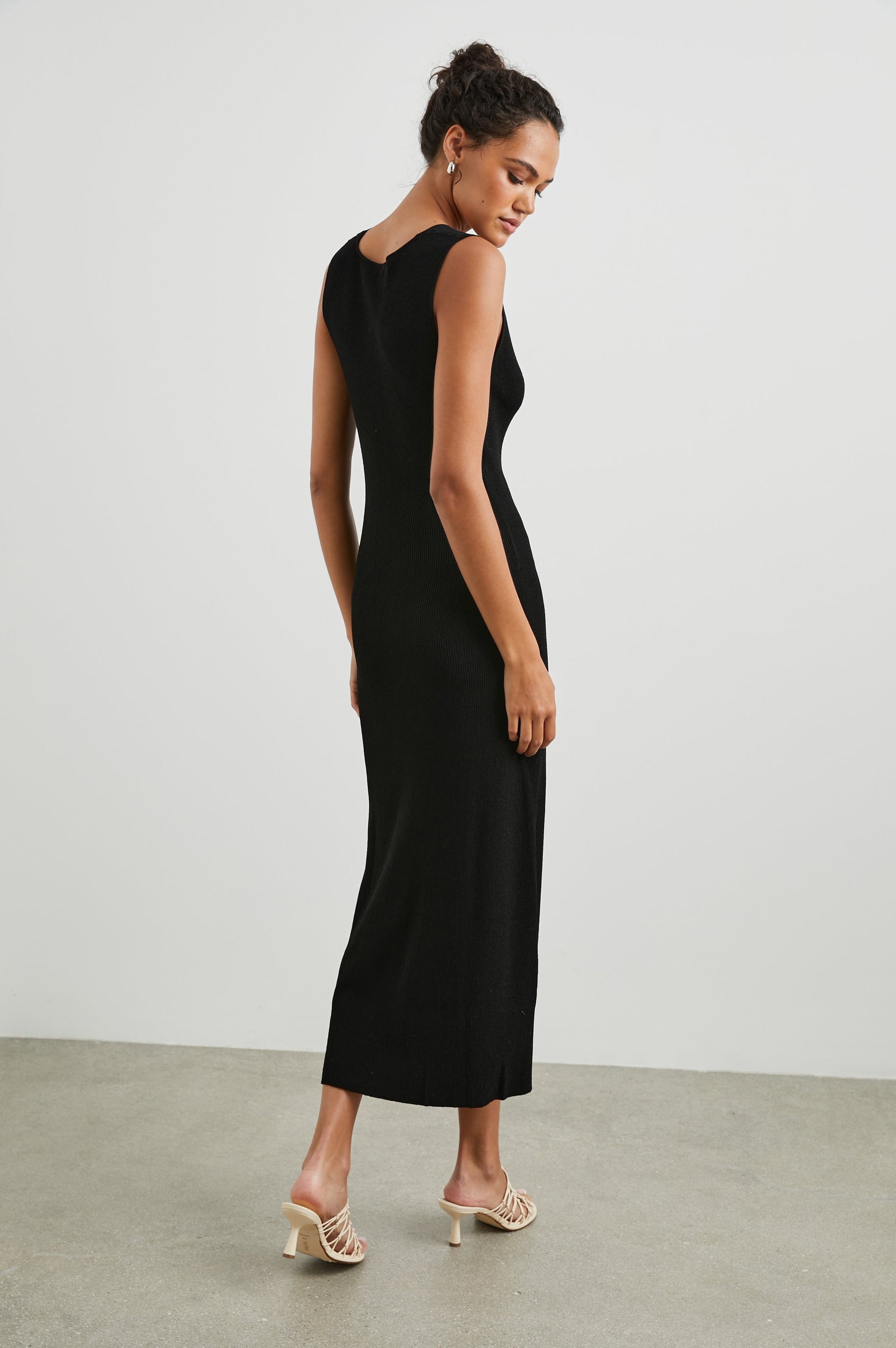 Teagan Sleeveless Ribbed Midi Dress with Wide Shoulder Straps and a Deep V Neck in Black Colorway - Back Full Body View Featured on Model 
