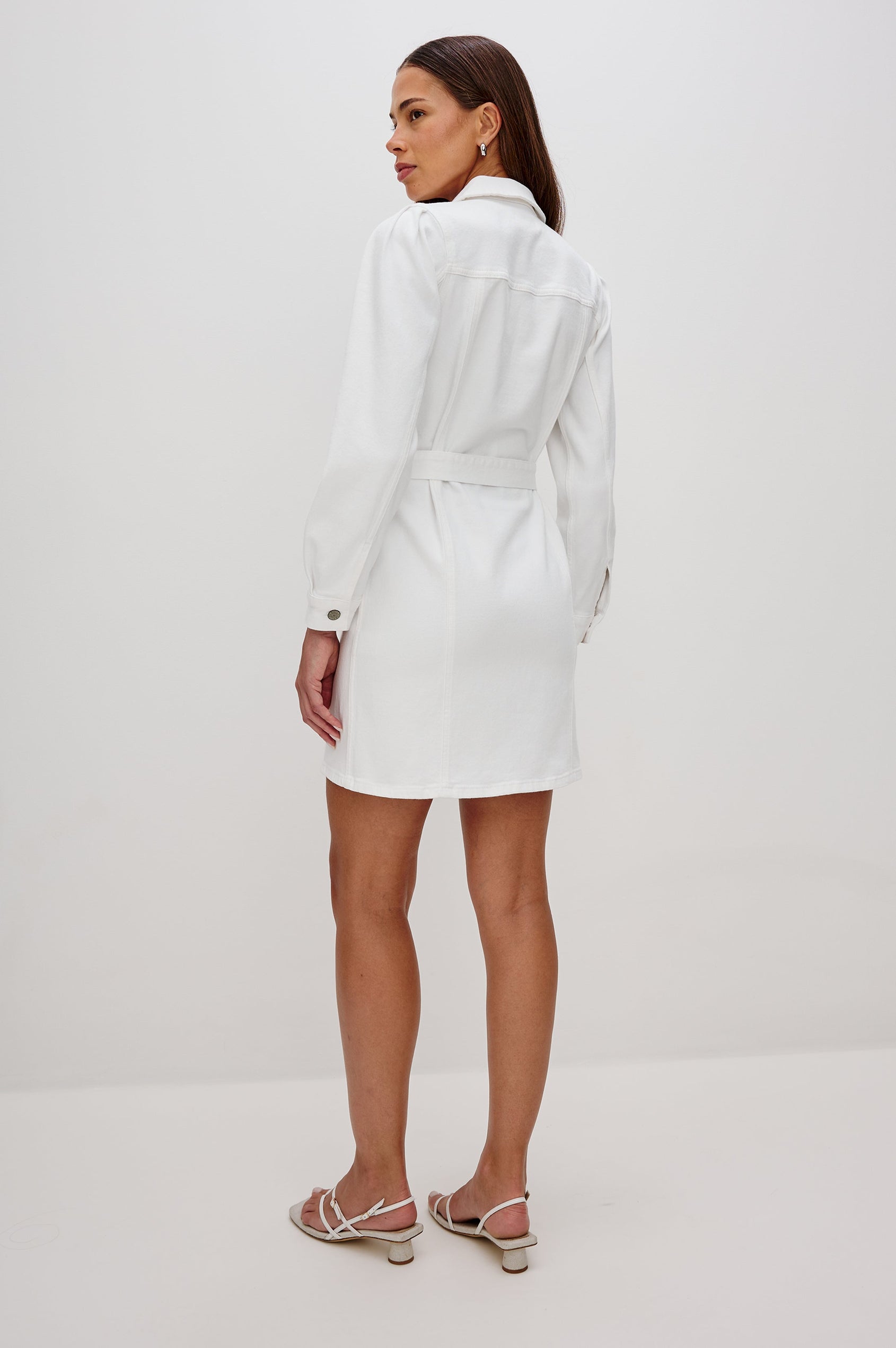 Griffith Denim Shirt Dress with Puff Shoulder Long Sleeves, Self Belt with Metal D-Rings and Chest Flap Pockets in Salt White Colorway. Full Body Back View Shown on Model.