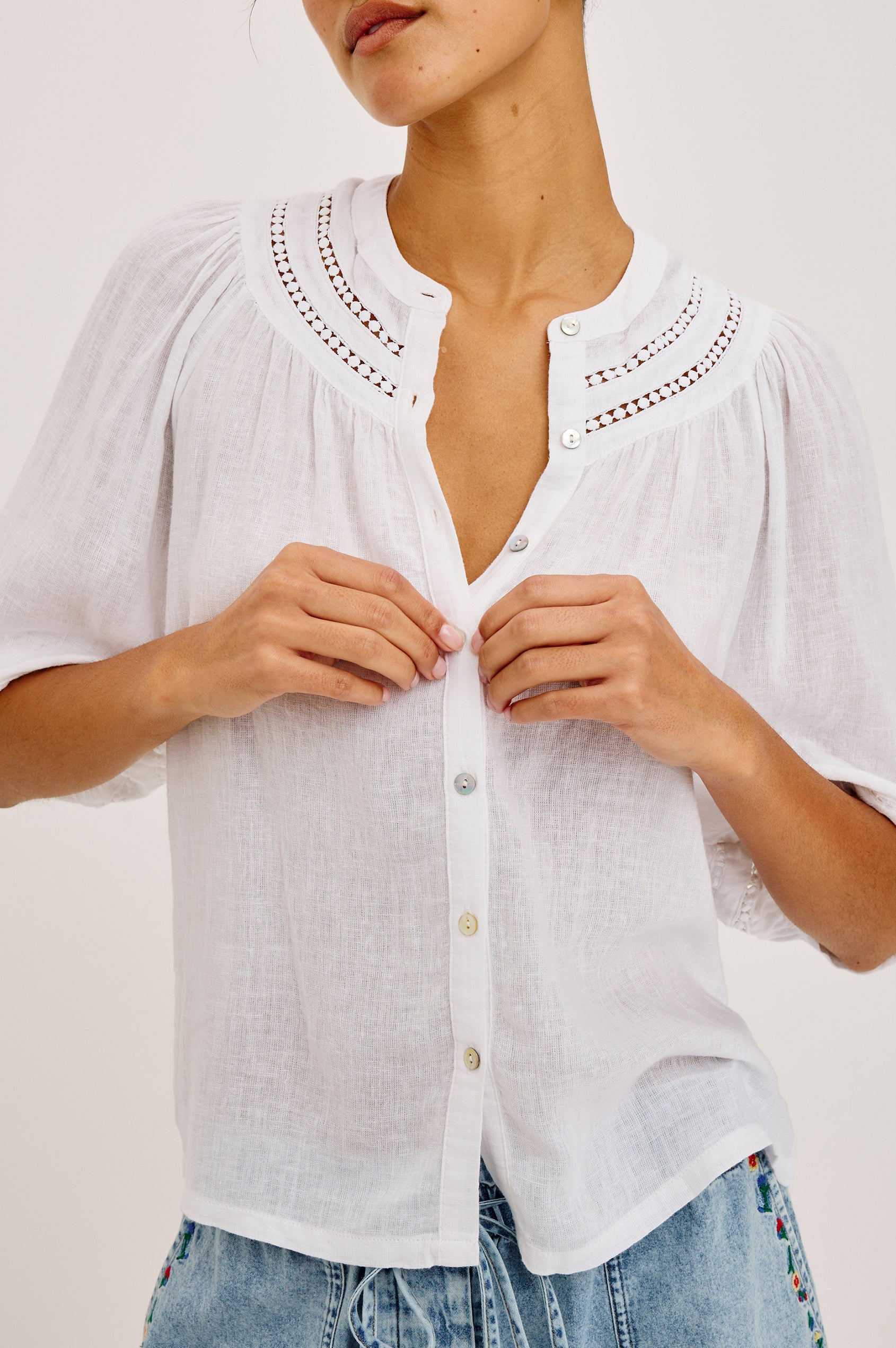 Theia Top in Luxe Linen With Crew Neckline, Front Buttons, Relaxed Fit, Embroidered Detailing, and Elbow-Length Puff Sleeves in White Colorway - Upper Body Front View Featured on Model