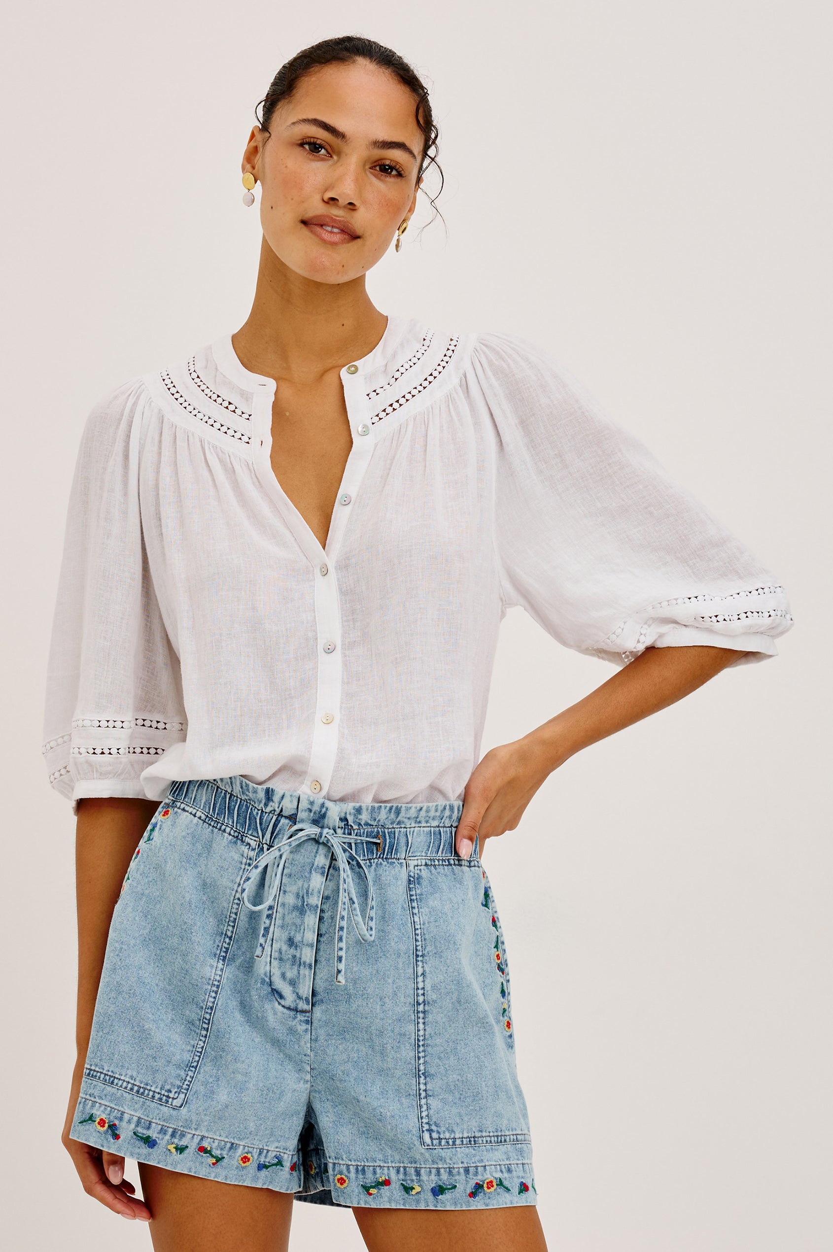 Theia Top in Luxe Linen With Crew Neckline, Front Buttons, Relaxed Fit, Embroidered Detailing, and Elbow-Length Puff Sleeves in White Colorway - Upper Body Front View Featured on Model