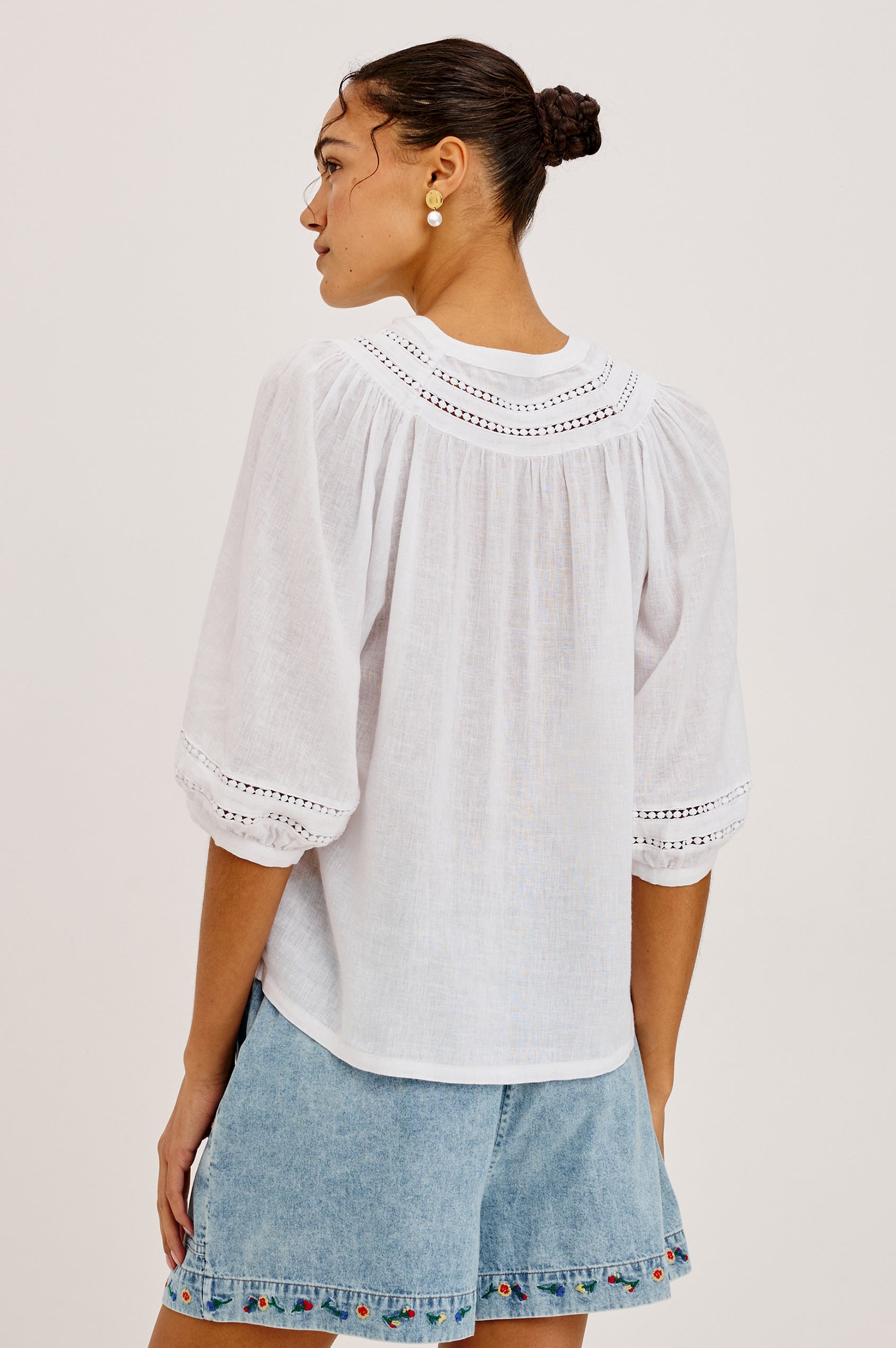 Theia Top in Luxe Linen With Crew Neckline, Front Buttons, Relaxed Fit, Embroidered Detailing, and Elbow-Length Puff Sleeves in White Colorway - Upper Body Back View Featured on Model