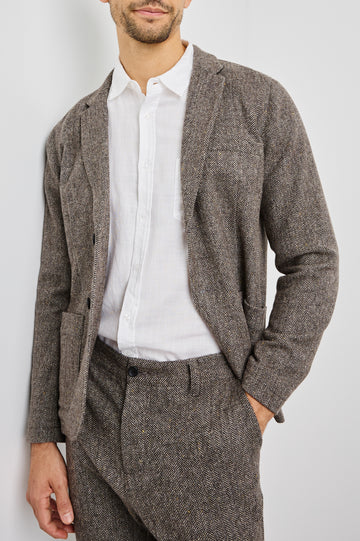 Reynard Blazer with Two Button Closure, Two Front Pockets, a Chest Welt Pocket, Herringbone Fabric in Highland Tweed Colorway, a Brown - Front View Featured on Model