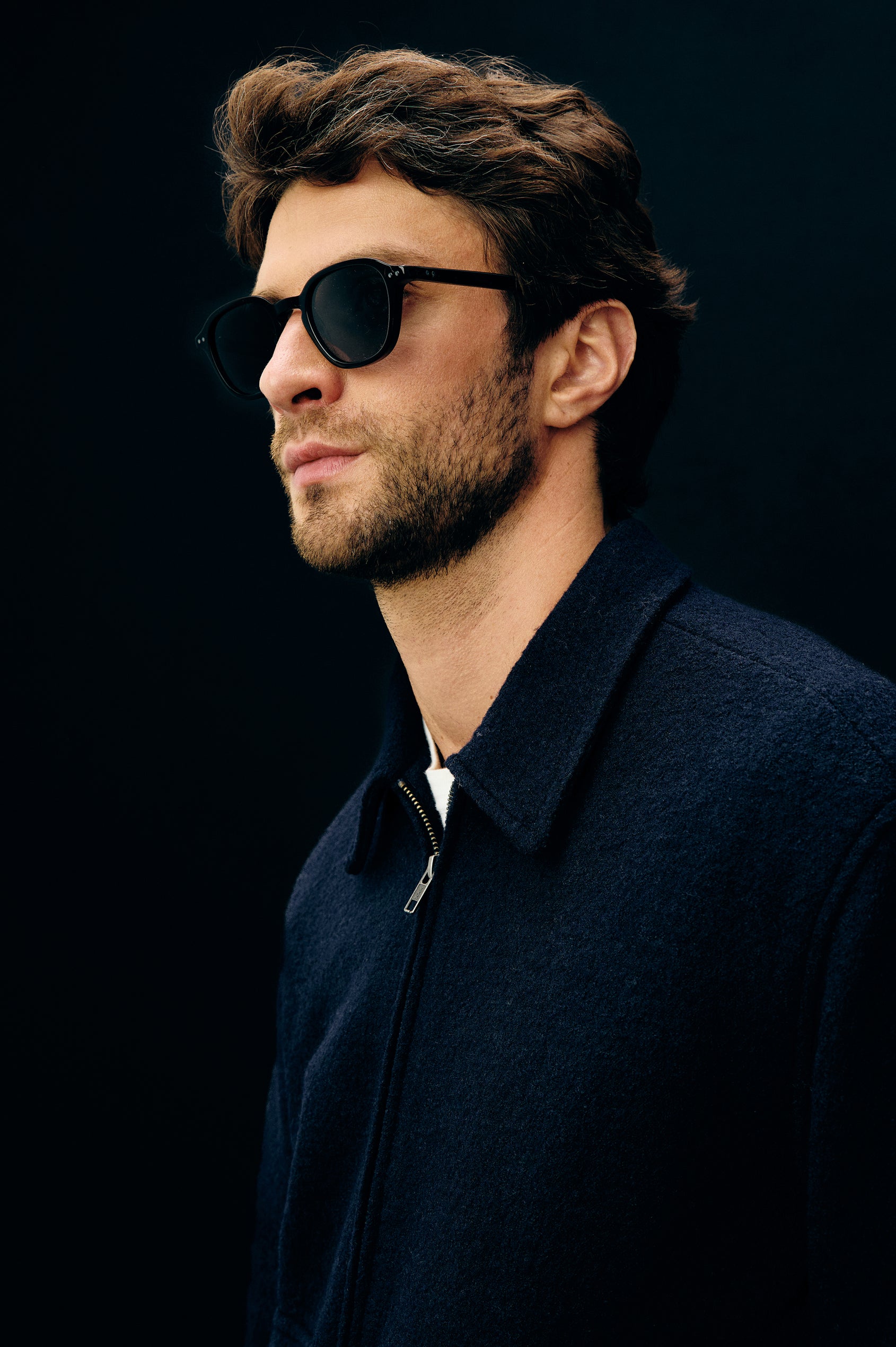 Tilman is a classic collar, front zip jacket, buttoned pockets with top and side entry in Navy Boucle colorway. Side headshot top detail view featured on model.