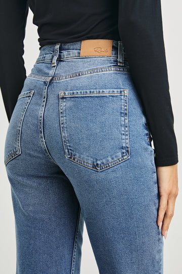 Topanga Crop Straight Jeans with an Asymmetrical Crop, Belt Loops, Two Front Pockets plus a Coin Pocket and Two Back Patch Pockets in Pure Indigo Colorway - Back View Featured on Model