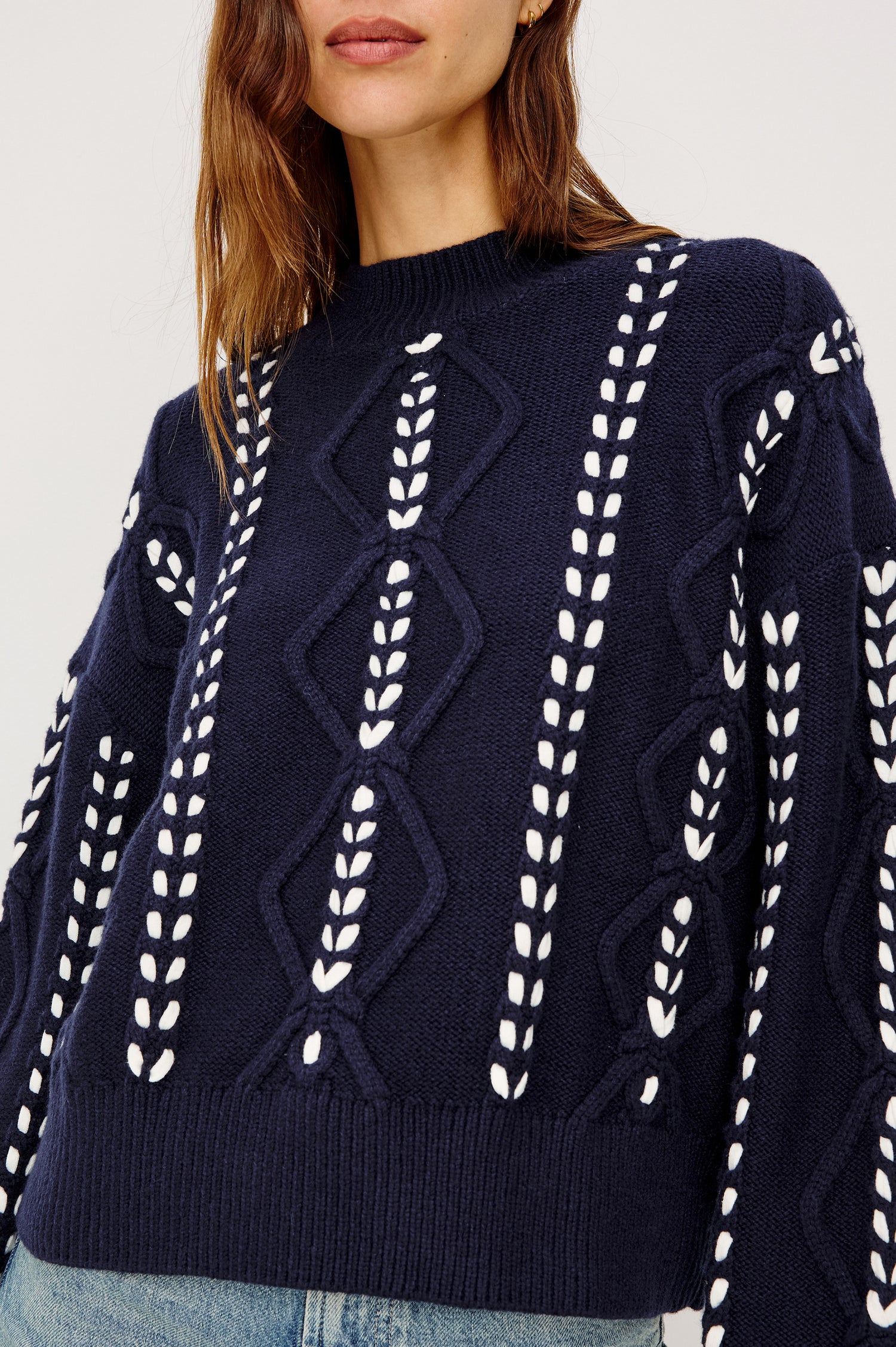 Tori Sweater in Wool Blend Cable Knit With Contrast Ribbon Stitching, a Ribbed Mock Neckline, Long Sleeves, and a Boxy Fit in Midnight Colorway - Upper Body Close Up Front View Featured on Model