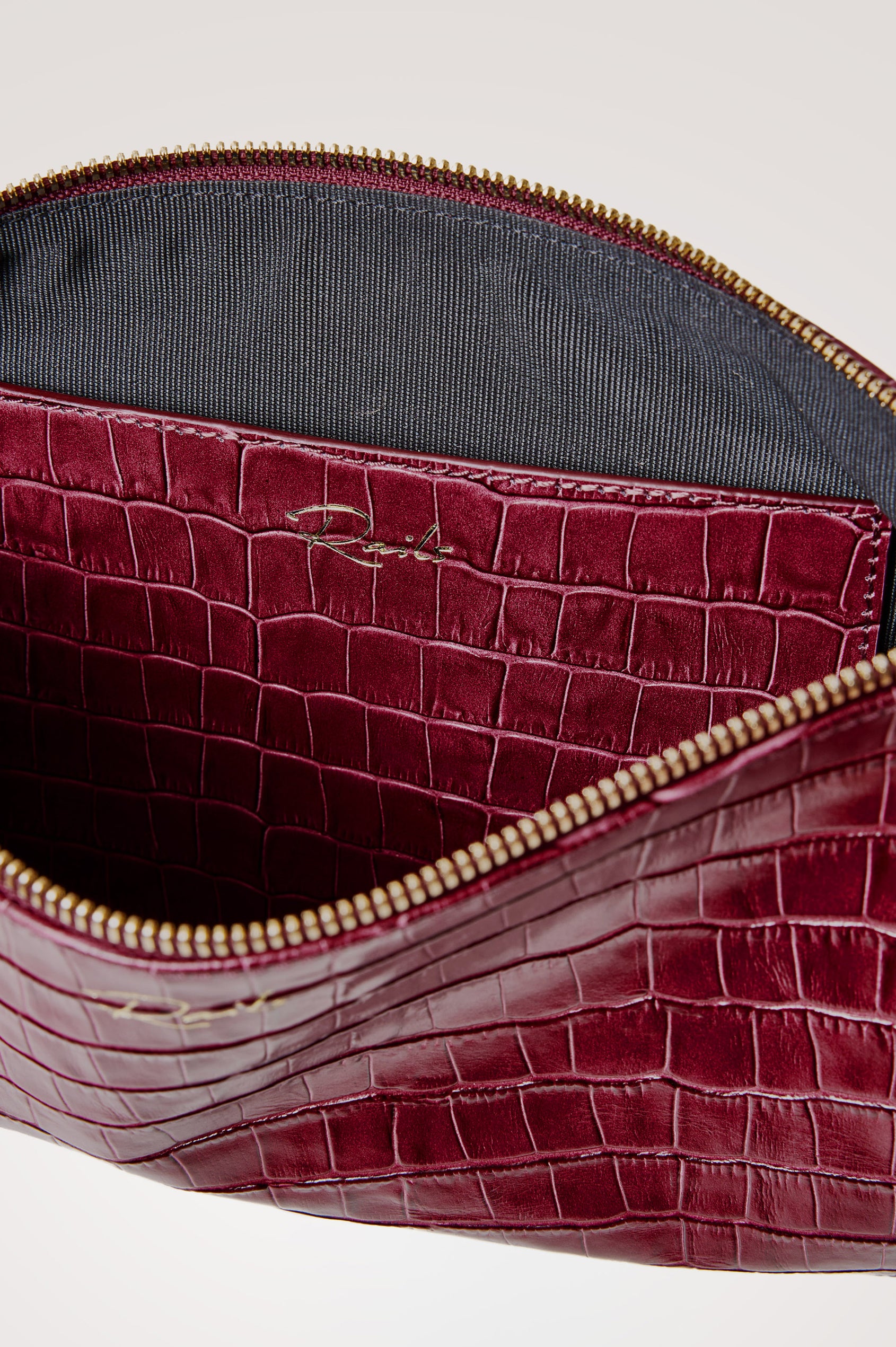 Verona Clutch Bag in Croc-Embossed Leather With Attached Wristlet Strap, Top Zip Closure, and Interior Slip Pocket in Burgundy Croc Embossed Colorway - Front Product View Featured