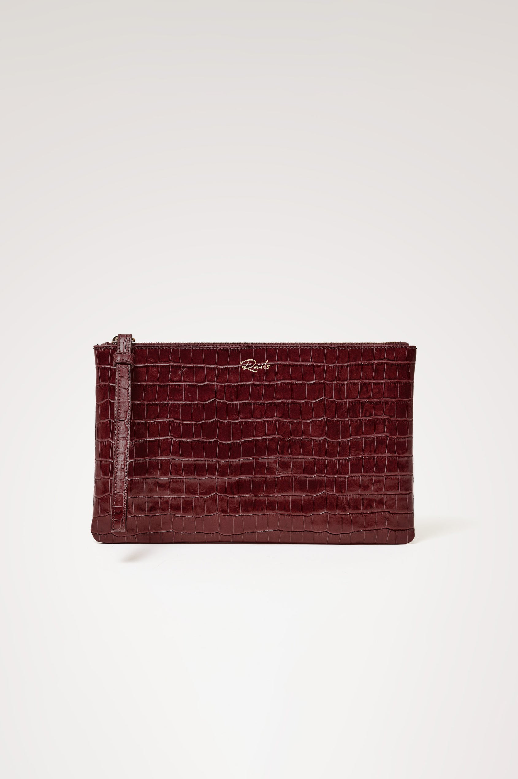 Verona Clutch Bag in Croc-Embossed Leather With Attached Wristlet Strap, Top Zip Closure, and Interior Slip Pocket in Burgundy Croc Embossed Colorway - Side View Featured on Model