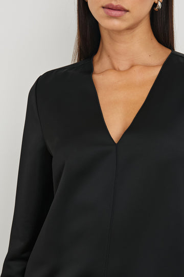 Victoria Long-Sleeve Mini Dress with a V Neck, and Front and Back Center Vertical Seams in Black Colorway - Front View Featured on Model 