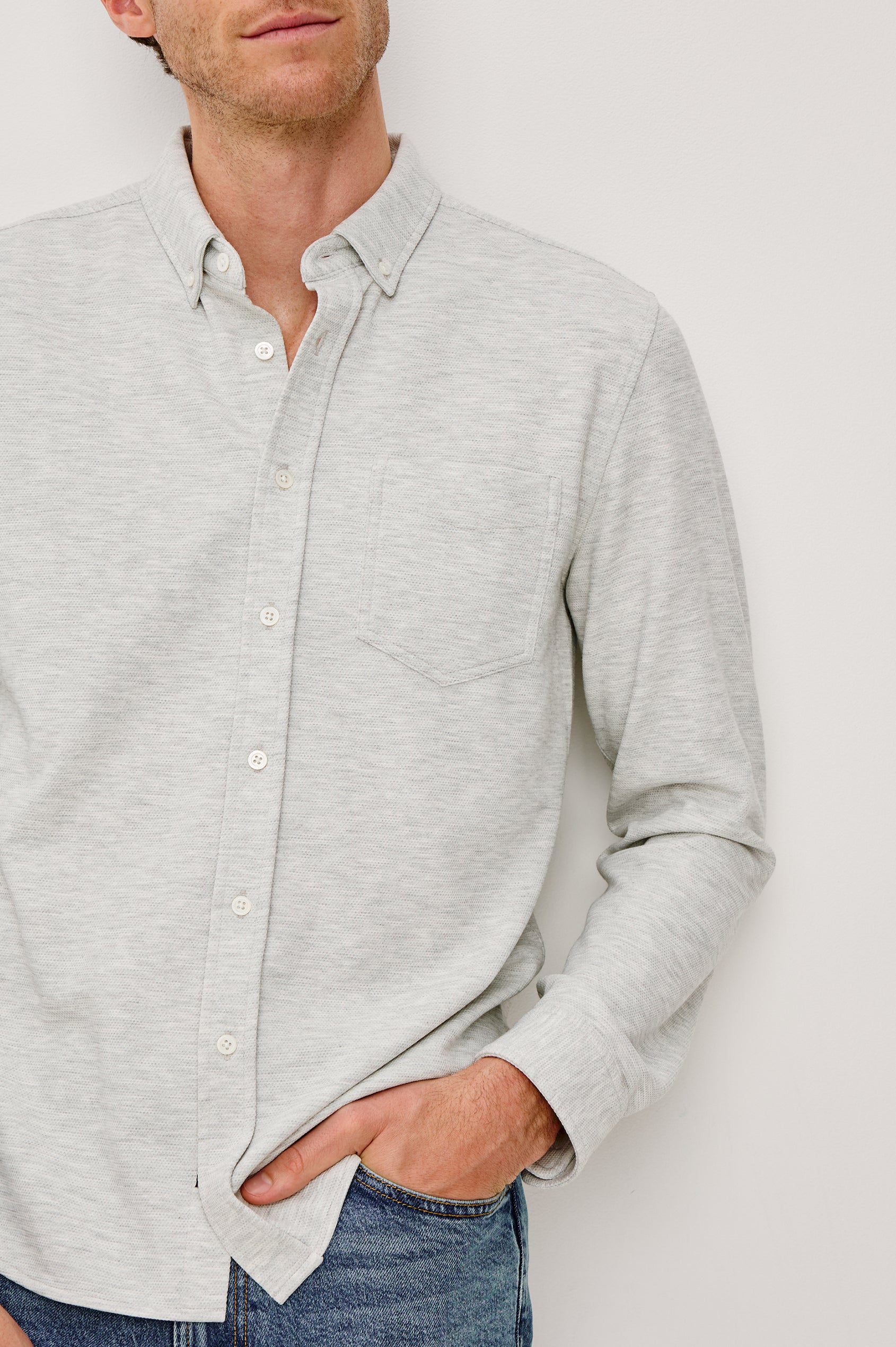 Vincent is a collared long sleeve button front shirt with a chest pocket in Heather Grey colorway. Front detail view featured on model.