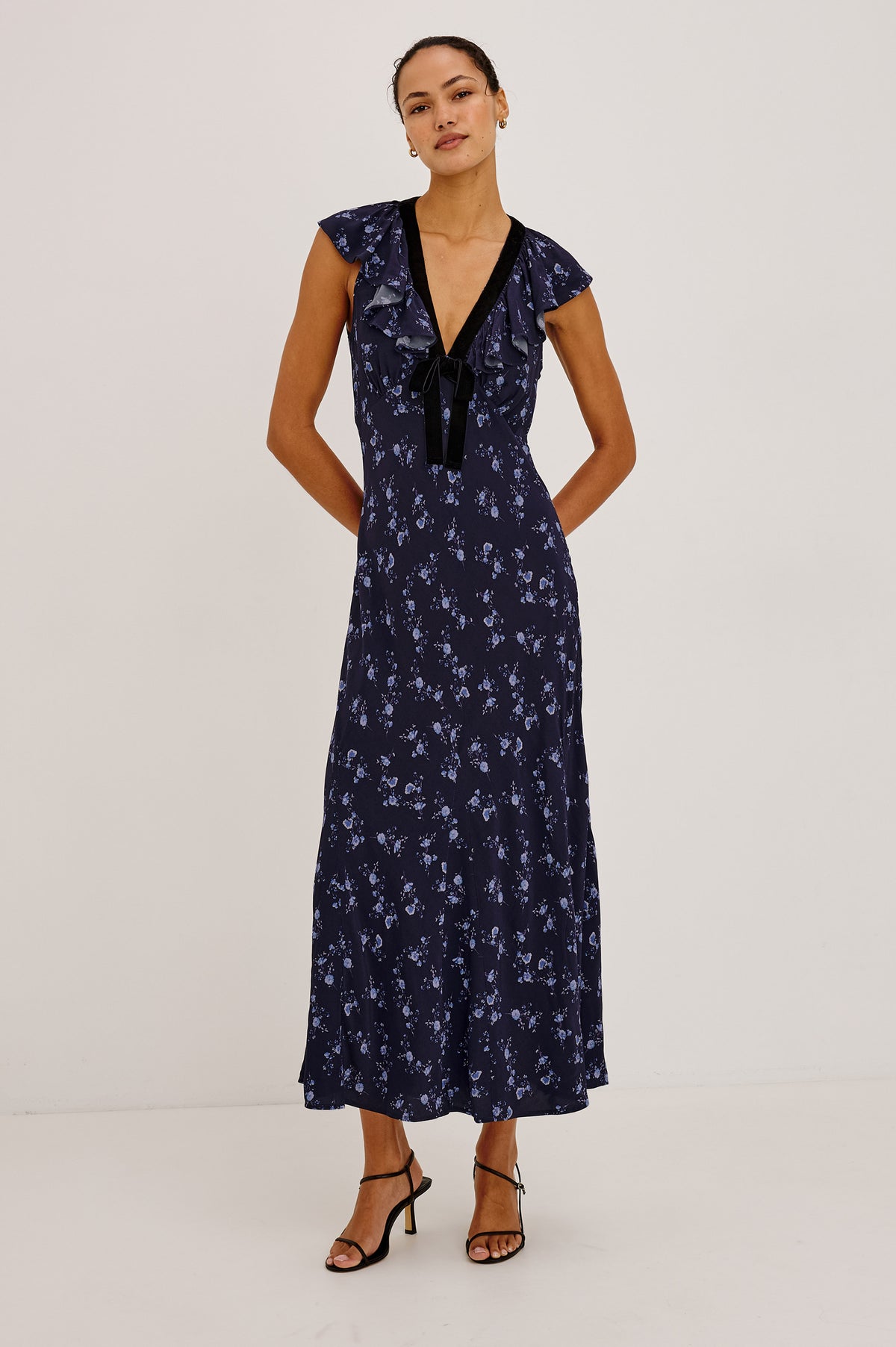 Virginia Maxi Dress in Lightweight Crepe With Ruffle-Trimmed Plunging V-Neckline With Center-Front Bow, Bias Cut, Side Zip Closure, and Godet Insets in Navy Romantic Floral Colorway - Full Body Front View Featured on Model.