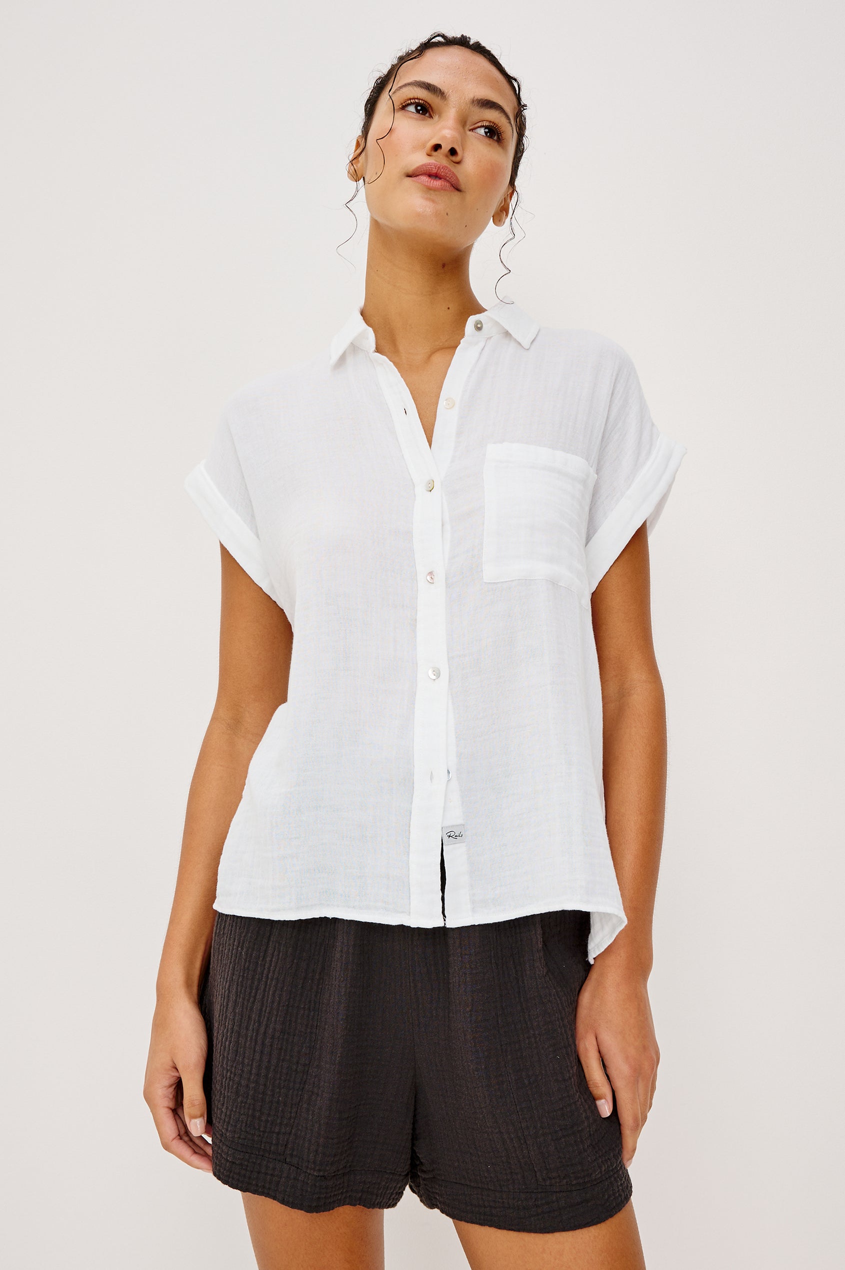 Whitney button front collared shirt with cuffed cap sleeve, features a chest pocket in white colorway. Front view featured on model