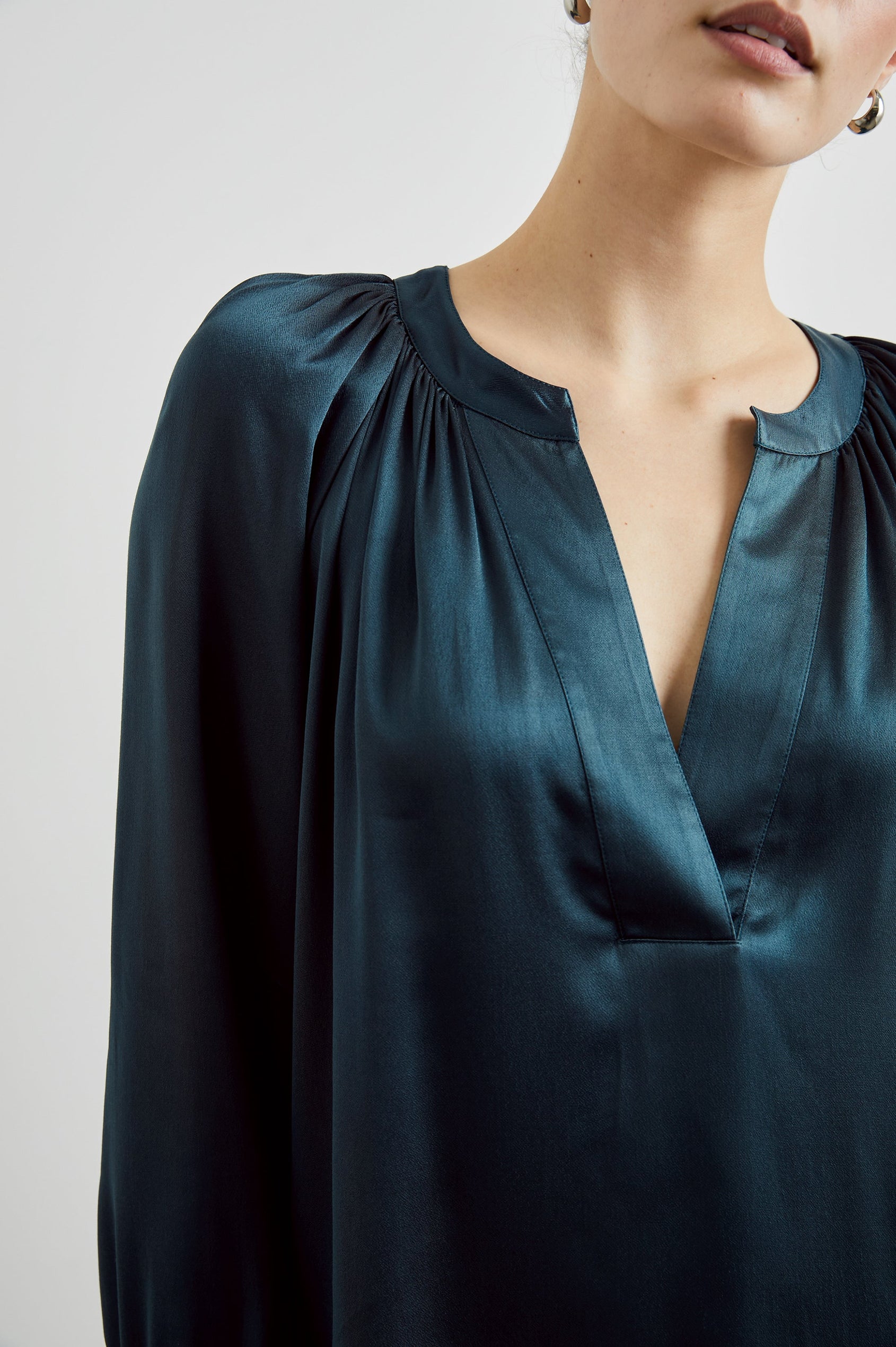 Wynna Long-Sleeve Top with a Deep V Neck and Ruching above the Cuffs and at the Neckline in Deep Sea Colorway - Front View Featured on Model