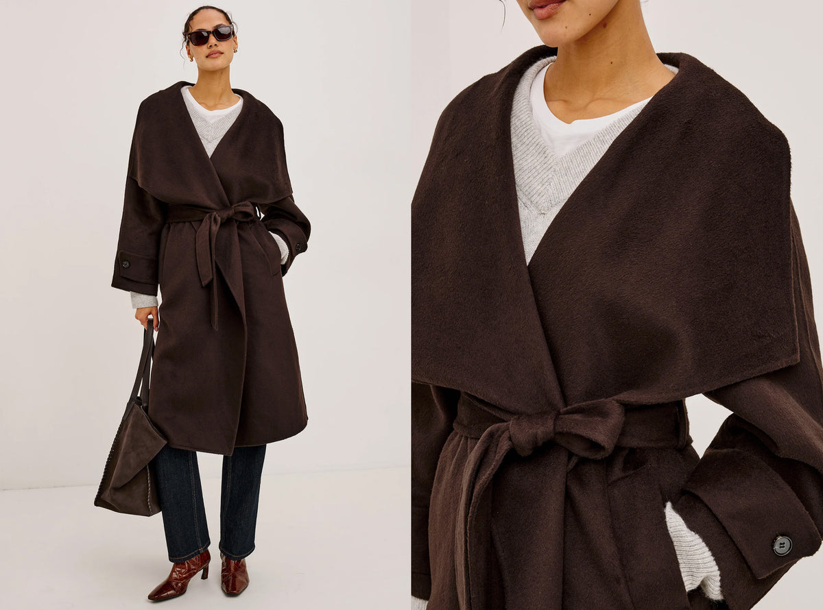 A dark brown wrap coat with a tie waist, shown on a model in a full-length view and a close-up view. The model is also wearing a white top, dark blue jeans, brown shoes, and holding a matching brown handbag.