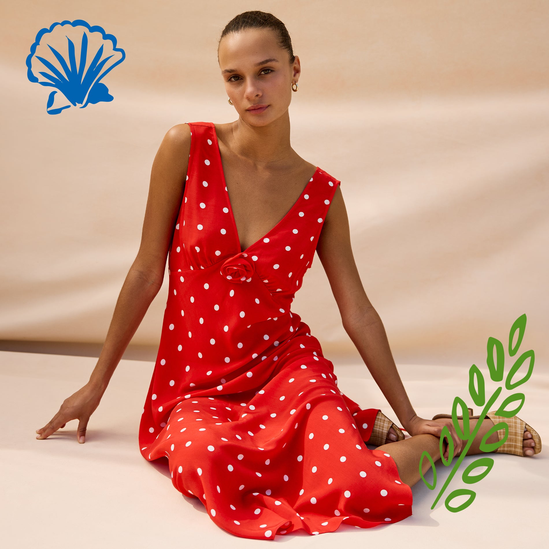 Woman wearing a red polka dot dress sitting on a beige surface with a brand logo in the corner.
