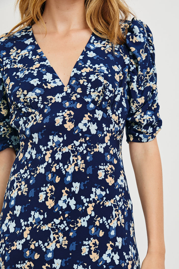 Zariah Midi Dress with Mid-Length Sleeves with Light Ruching, a Deep V Neck and an Empire Waist in Navy Flora Colorway, flowers in orange and blues on Navy - Front View Featured on Model
