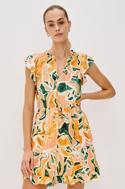 Zinnia Popover Mini Dress with Short Flutter Sleeves, Small Ruffle at Neck, V-Front with Self Tie Closure, Ruffle Hem in Tulum Colorway. Front View Shown on Model.