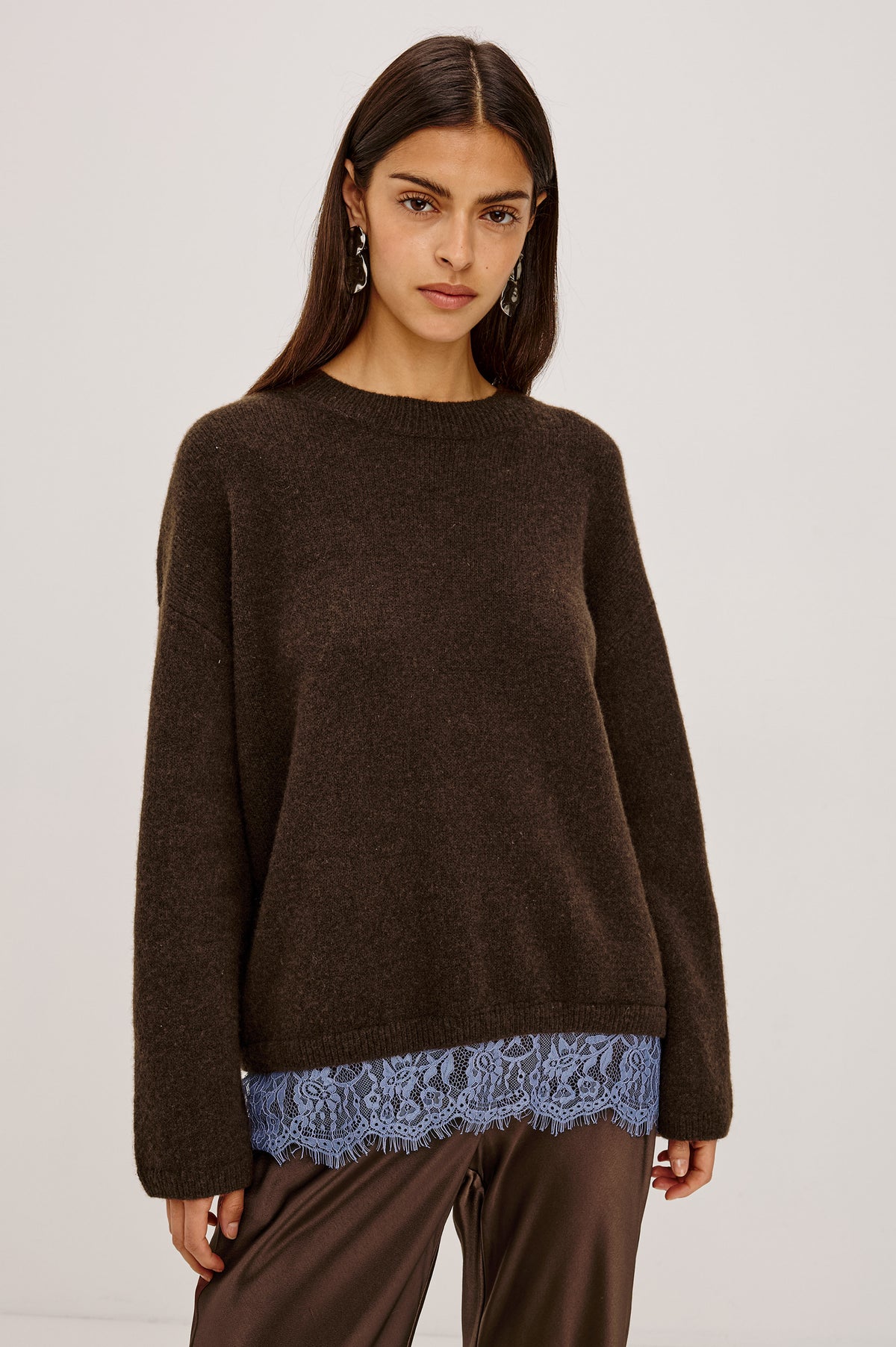 Zoie Sweater in Merino Wool Blend With Contrast Lace Inset Hem for Layered Look, Long Sleeves, and Slightly Oversized Fit in Espresso Blue Lace Colorway - Upper Body Front View Featured on Model.