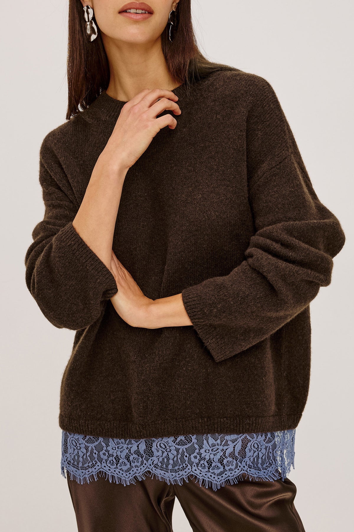 Zoie Sweater in Merino Wool Blend With Contrast Lace Inset Hem for Layered Look, Long Sleeves, and Slightly Oversized Fit in Espresso Blue Lace Colorway - Upper Body Front Detail View Featured on Model.