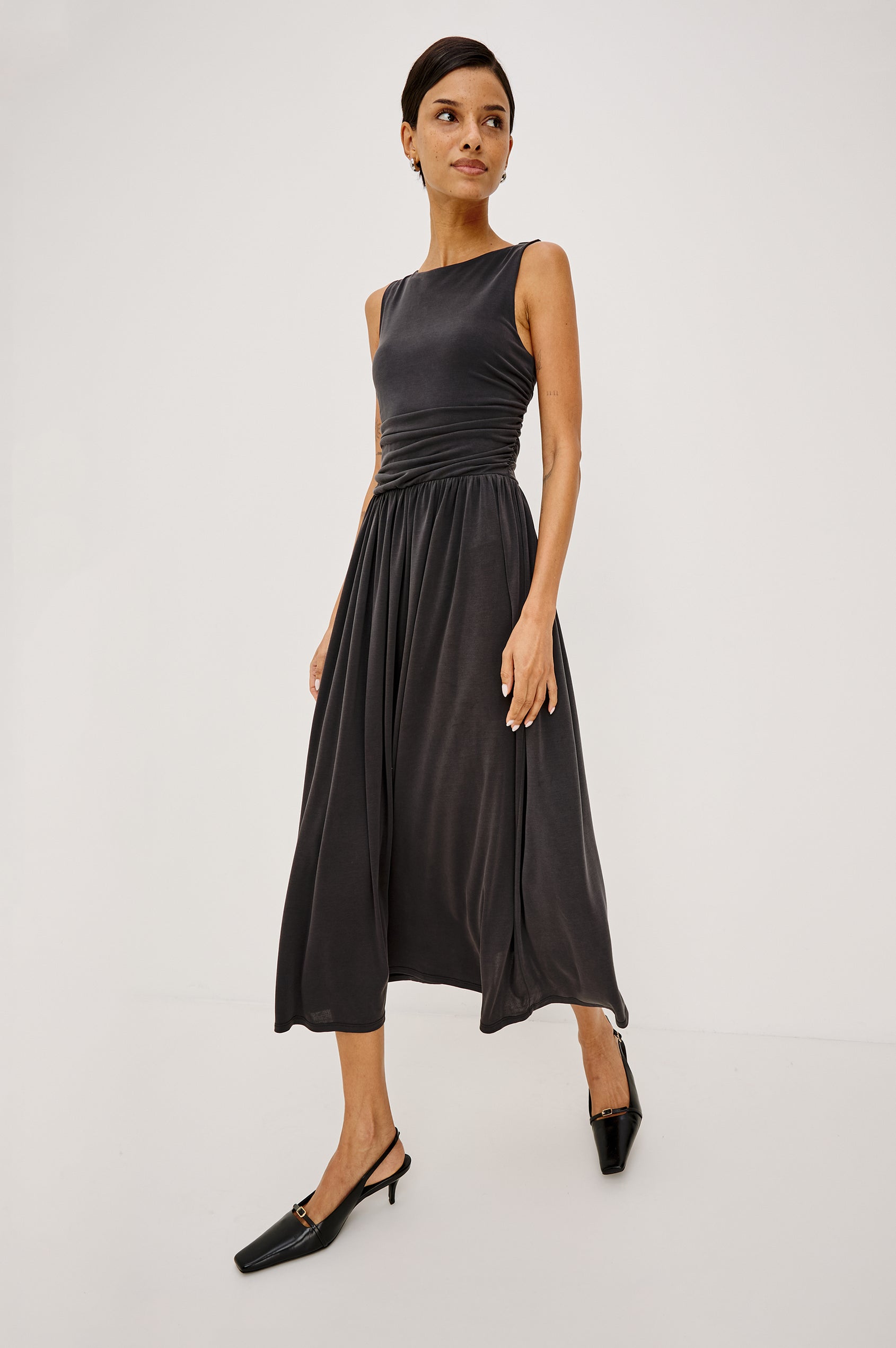 Zora Maxi Dress in Peached Jersey With Fitted Ruched Bodice, Shirred A-Line Skirt, Sleeveless Cut, and Crew Neckline in Ash Colorway - Full Body Front View Featured on Model