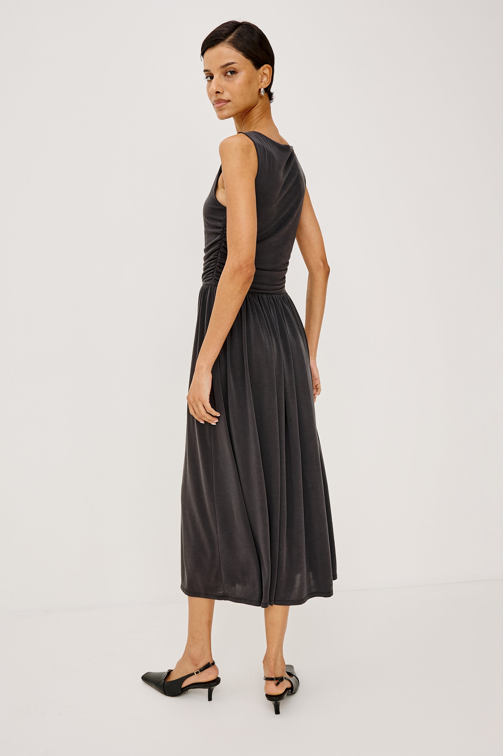 Zora Maxi Dress in Peached Jersey With Fitted Ruched Bodice, Shirred A-Line Skirt, Sleeveless Cut, and Crew Neckline in Ash Colorway - Full Body Back View Featured on Model