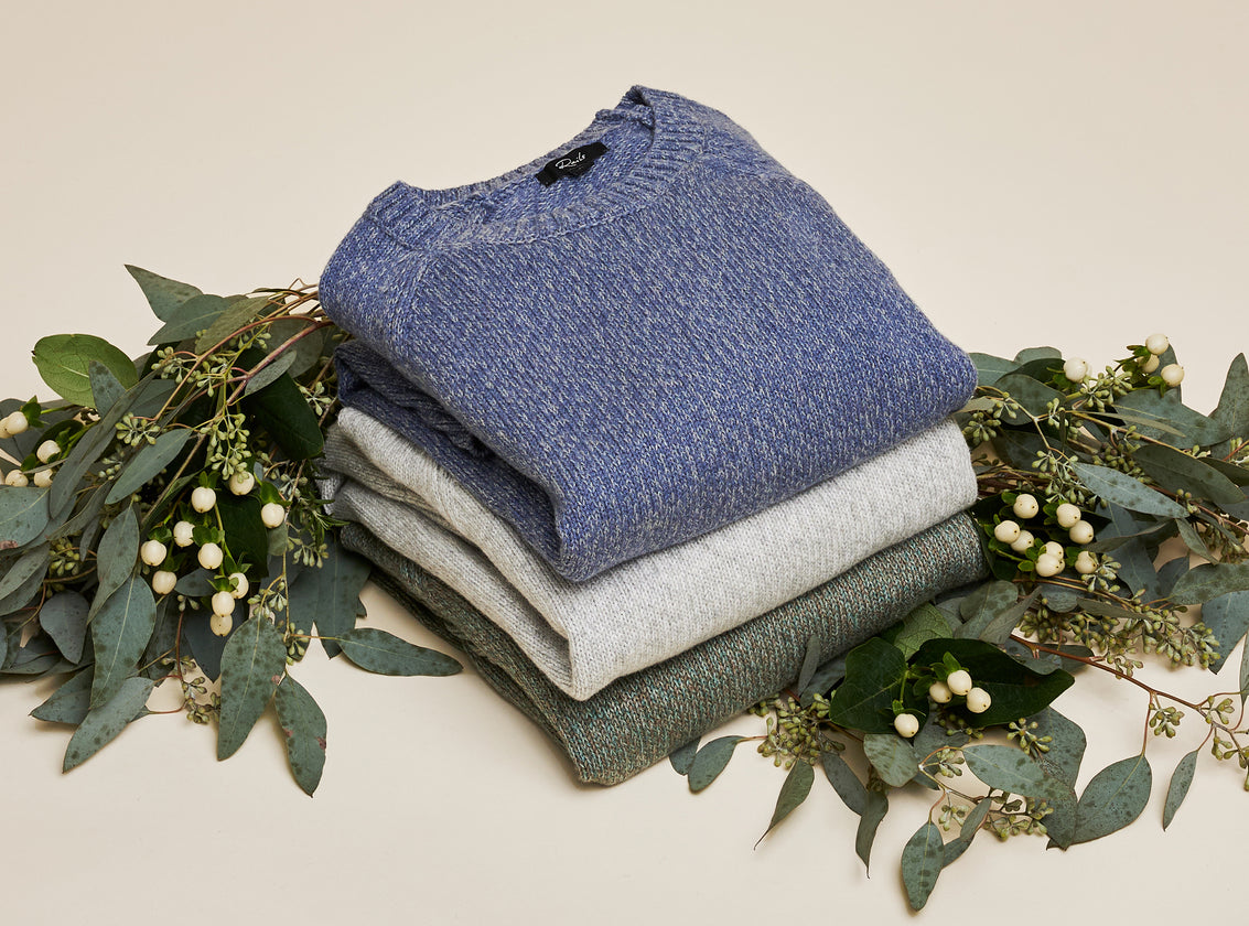 EDITORIAL IMAGE OF MULTIPLE SWEATERS FOLDED AND STACKED ON TOP OF EACH OTHER
