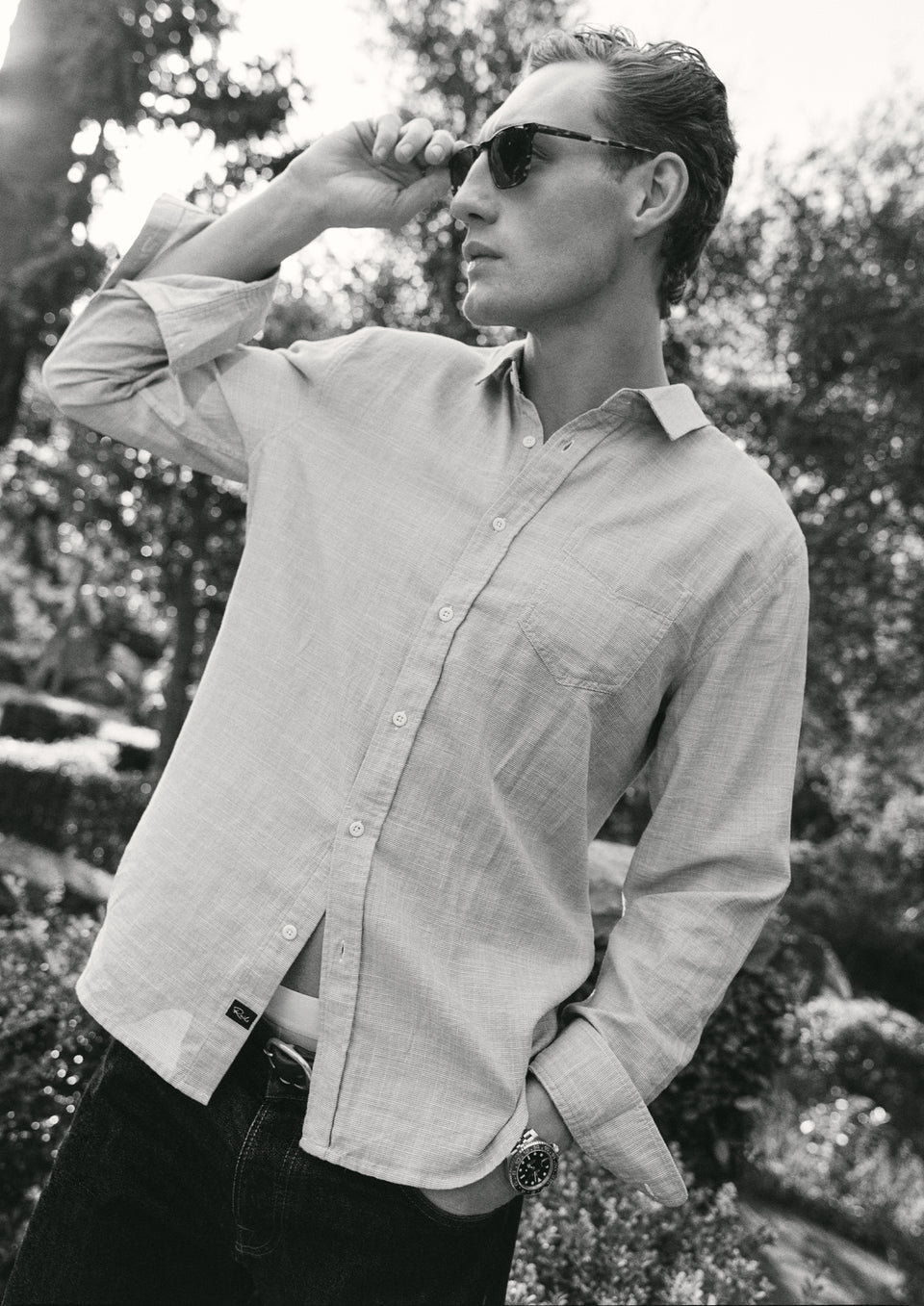 Man wearing a light-colored shirt and sunglasses outdoors