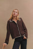 (Video): Rayleen Cardigan in Brown Ivory Blanket Stitch shown on a model to showcase the soft cotton yarn, relaxed fit, collared neckline, and blanket-stitched detailing. Full Body View Featured on Model.