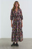 Caterine Maxi Dress with Mid-length Sleeves, a V neck, a Shirred Collar with a tie, a Smocked Waist, and a Tiered Skirt in Navy Wildflower Colorway, flowers in creams, pinks, greens and blues on Navy - Full Body Video on Model.