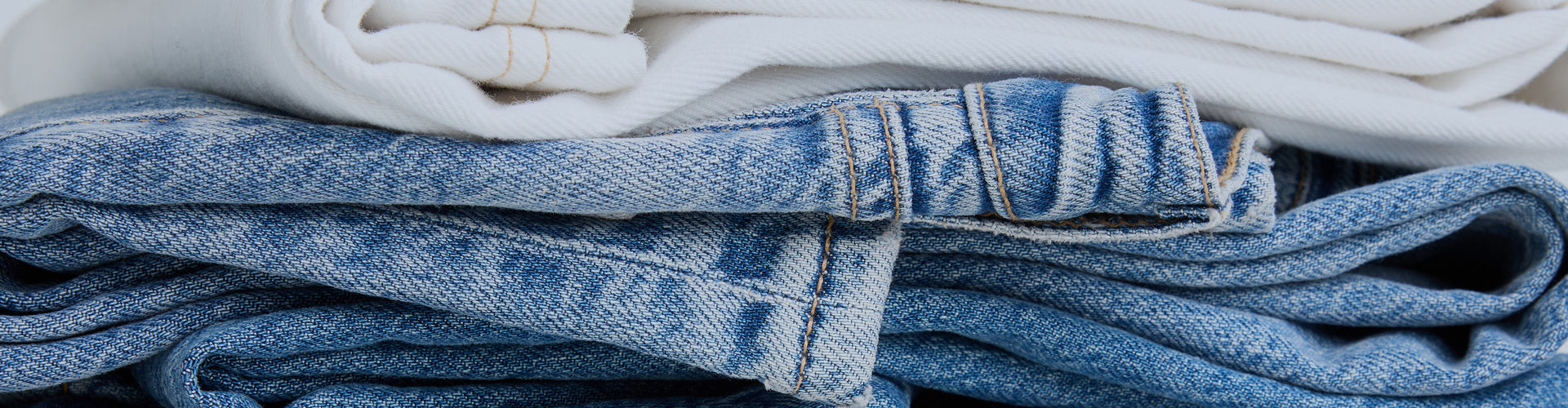 Stack of folded blue jeans with a blurred background