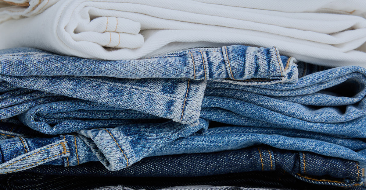 Stack of folded blue jeans with a blurred background
