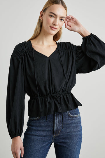 Abra Long-Sleeve Top with a V Neck, a Drawstring From Each Sleeve Shoulder to the Neckline, a Drawstring Above the Hem and Billowy Sleeves in Black Colorway - Front View Featured on Model 