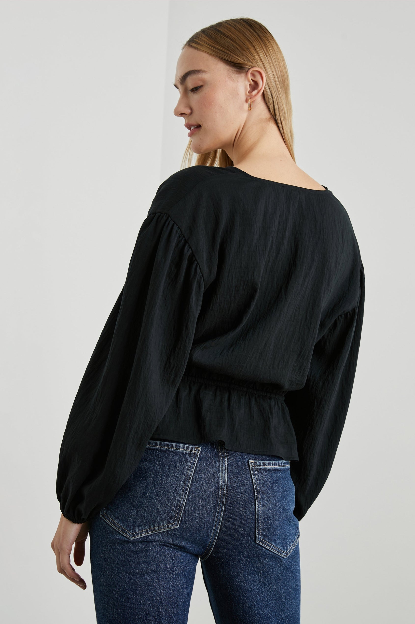 Abra Long-Sleeve Top with a V Neck, a Drawstring From Each Sleeve Shoulder to the Neckline, a Drawstring Above the Hem and Billowy Sleeves in Black Colorway - Back View Featured on Model 