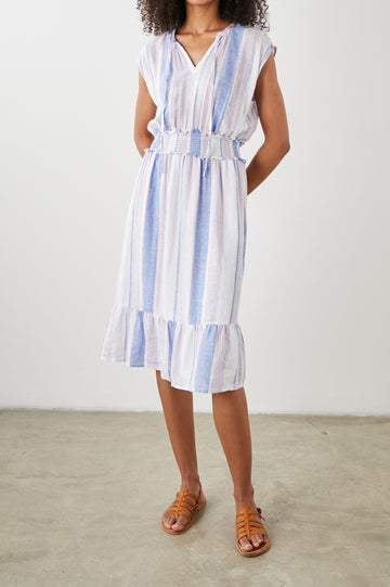 Ashlyn Short Sleeve Midi Dress with a V neck with Ties, a Smocked Waist and a Ruffle Tier at the Hem in Marini Stripe Colorway, Vertical Stripes in Pink and Blue on White - Front Full Body View Featured on Model