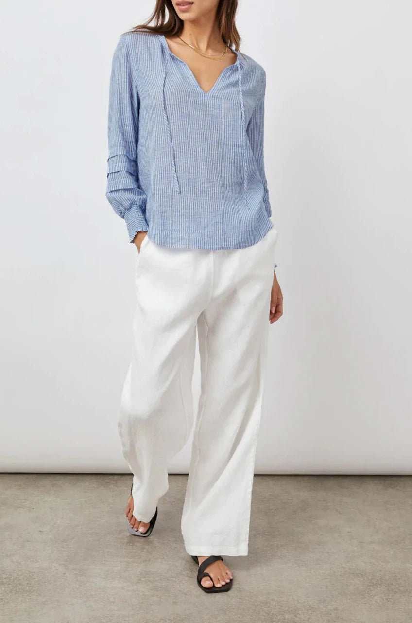 Caterina Long-Sleeve Top with a V neck, Neck Ties, Shirred Cuffs and Horizontal Pleats on the Sleeves in Sanibel Stripe Colorway, Thin White and Blue Vertical Stripes - Front Full Body View Featured on Model
