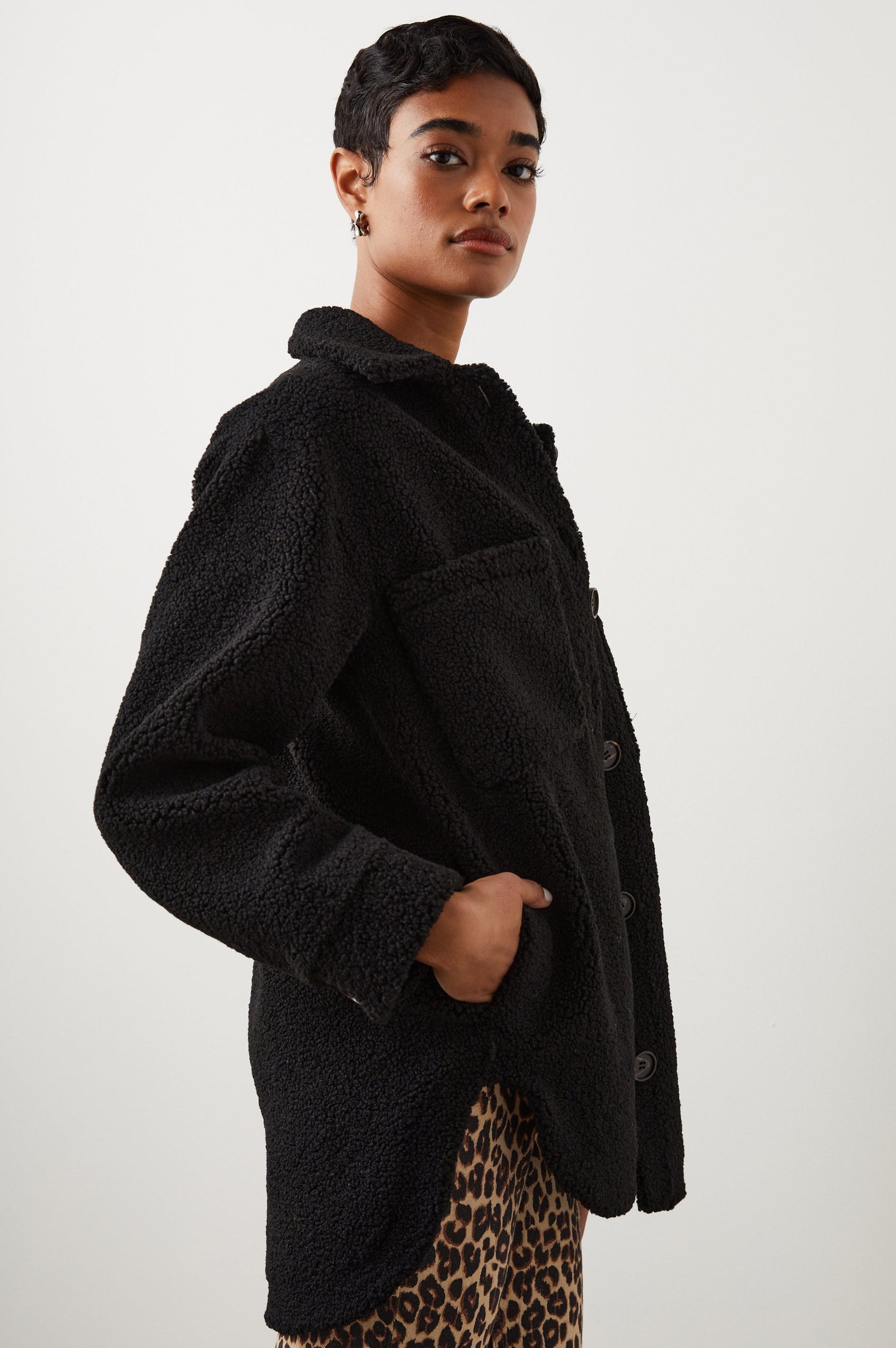 Connie Fleece Shirt Jacket with Button Closure, Two Front Pockets and Two Chest Patch Pockets in Black Teddy Colorway - Side View Featured on Model 