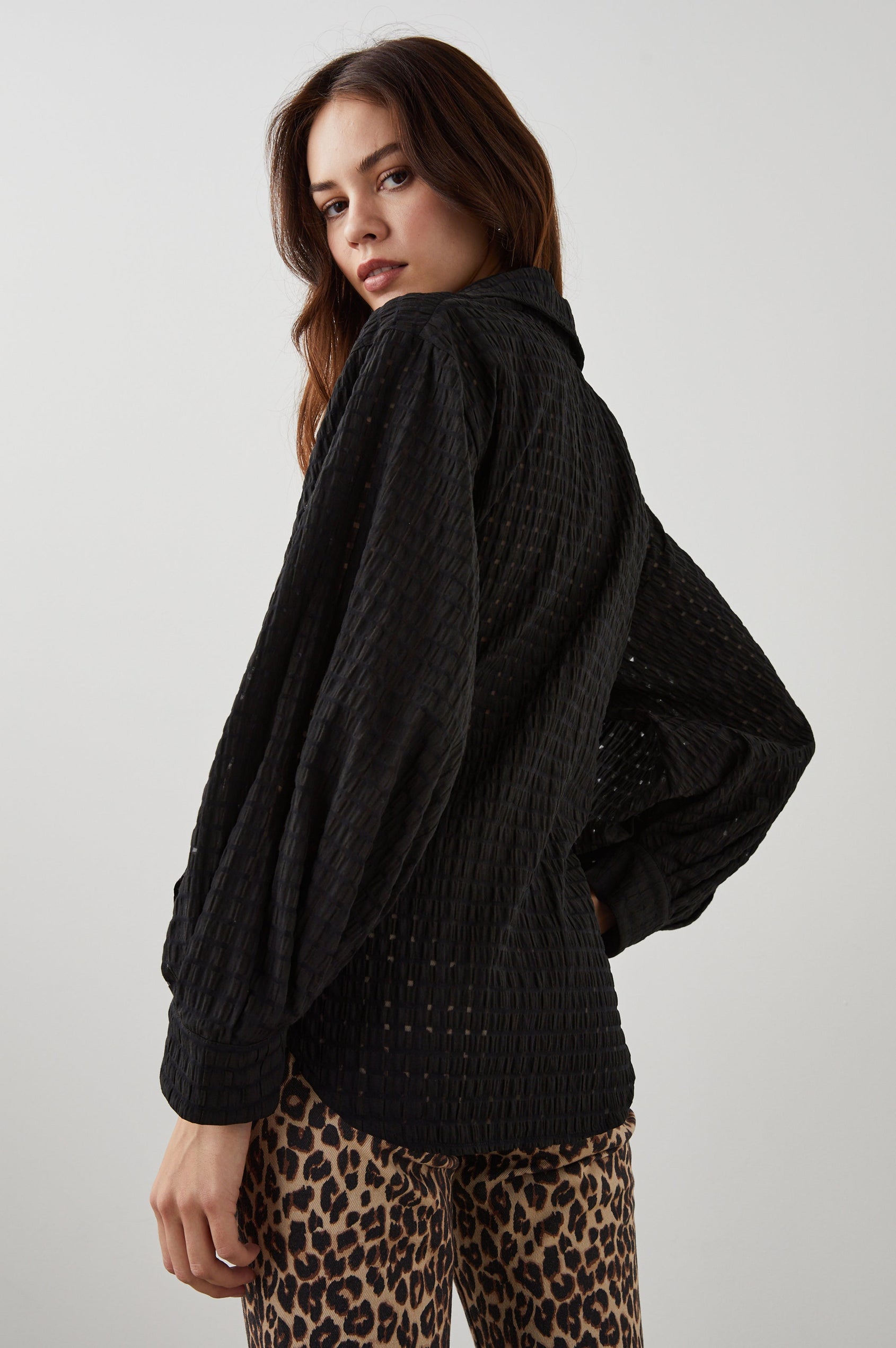 Eileen Long-Sleeve Wrap Top with Textured Fabric, a Deep V Neck, a Collar, a Wrap Tie at the Waist, Billowy Sleeves, in Black Seersucker Colorway - Back View Featured on Model 
