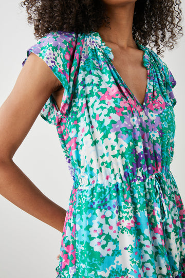 Juni Short Sleeve Midi Dress with a V Neck, Light Ruching along the Neckline, a Drawstring Waist, and a Tiered Skirt in Gardenia Floral Colorway, in Greens, Blues, Purples, Pinks and White - Front View Featured on Model