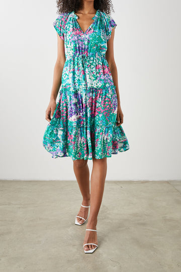 Juni Short Sleeve Midi Dress with a V Neck, Light Ruching along the Neckline, a Drawstring Waist, and a Tiered Skirt in Gardenia Floral Colorway, in Greens, Blues, Purples, Pinks and White - Front View Featured on Model