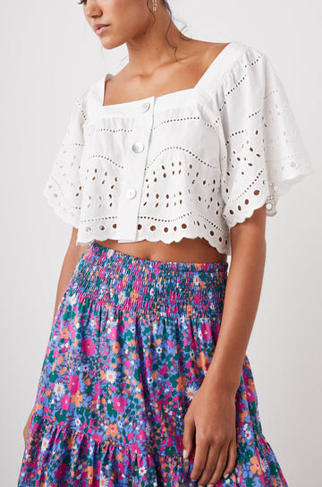 Kit Short Sleeve Crop Top with a Square Neckline, Front Button Closure, and an Eyelet Design in White Eyelet Embroidery Colorway - Front View Featured on Model 