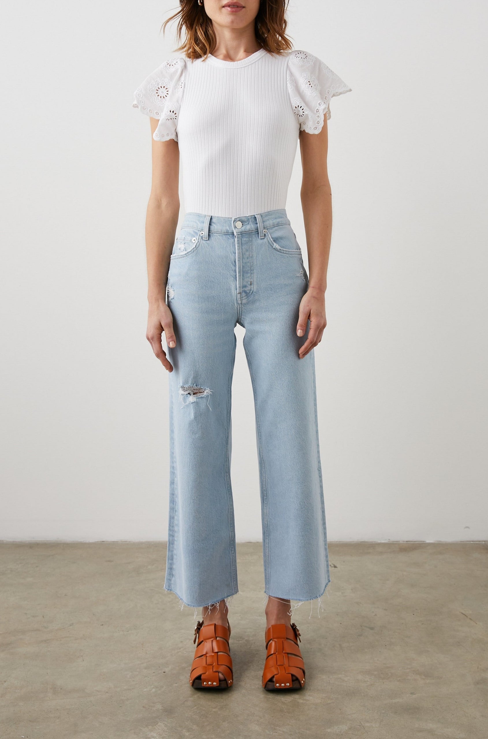 Reza Ribbed Short Sleeve Top with Flutter Sleeves, a Crew Neck and Floral Eyelets on the Sleeves in White Colorway - Front Tucked Full Body View Featured on Model 