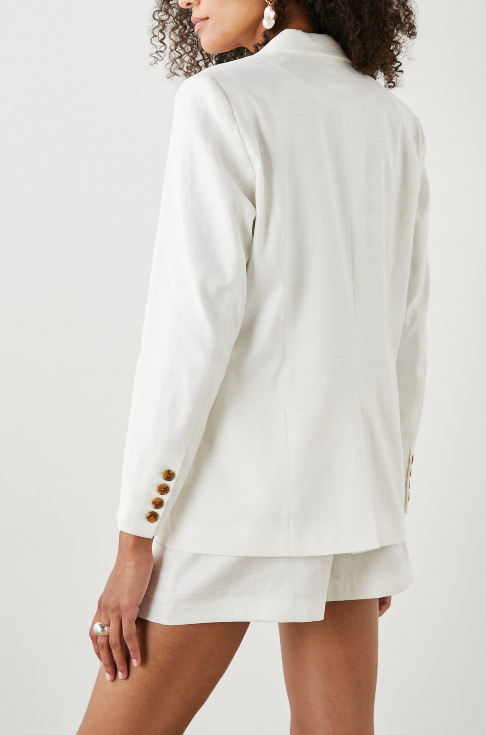 Stanton Blazer with Two Button Closure, Two Front Flap Pockets, a Chest Patch Pocket and Four-Button Cuffs in Creme Colorway - Back View Featured on Model
